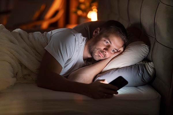 man in bed with phone