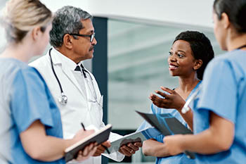 A doctor and three nurses in a discussion