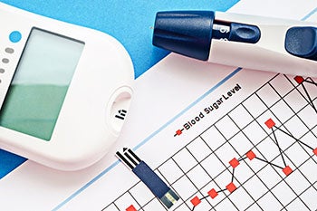 A glucometer and epipen on top of a printed out graph